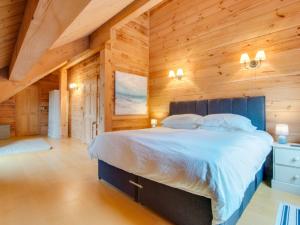 Little PetherickにあるHoliday Home Rosehill by Interhomeの木製の壁のベッドルーム1室(大型ベッド1台付)