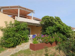 una casa con due alberi e fiori davanti di Apartment Vista Playa 2 by Interhome a Pittulongu