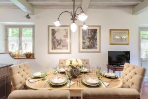a dining room with a wooden table and chairs at Villa D'Amico, charming indulgence overlooking Lucca Town Centre in Lucca