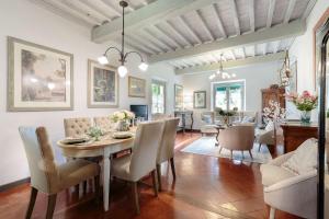 a dining room and living room with a table and chairs at Villa D'Amico, charming indulgence overlooking Lucca Town Centre in Lucca