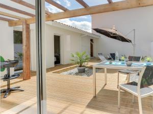 eine Terrasse mit einem Tisch und Stühlen auf einer Holzterrasse in der Unterkunft Apartment Les Patios de Flore-1 by Interhome in Mimizan-Plage