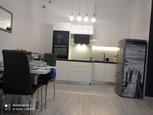 a kitchen and dining room with a table and a refrigerator at Aqua Blue Apartament in Reda