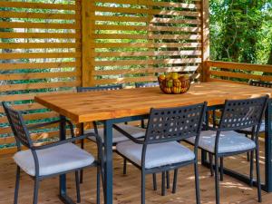 a wooden table and chairs on a patio at Holiday Home Klen 2 by Interhome in Hreljići +16 photos