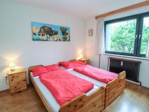 een slaapkamer met een groot houten bed met rode lakens bij Apartment Spatzennest - Top 7 by Interhome in Grünau im Almtal +30 foto's