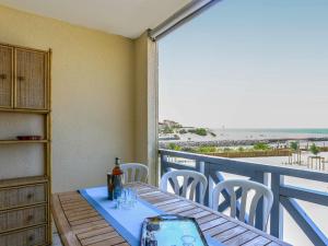 a table on a balcony with a view of the beach at Apartment Grand Pavois-4 by Interhome in Mimizan-Plage