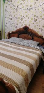 łóżko z drewnianym zagłówkiem i ścianą w obiekcie Сomfort&Servis Apartment on Mira of Yuzhny w mieście Jużne