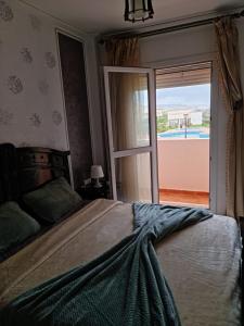 a bedroom with a large bed and a sliding glass door at FamilyConfort Saidia in Saïdia