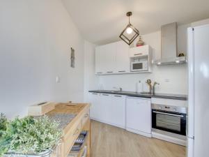 cocina con armarios blancos y encimera en Apartment Port Blanc by Interhome en Port Blanc