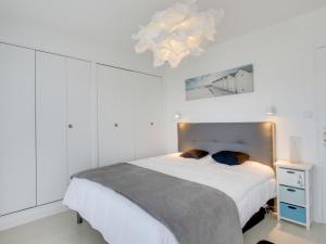 Port Blanc的住宿－Apartment Port Blanc by Interhome，一间卧室配有一张大床和一个吊灯。