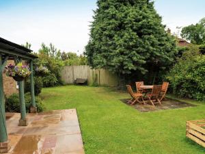 a patio with a table and chairs in a yard at Holiday Home Woodhouse-5 by Interhome in Shermanbury