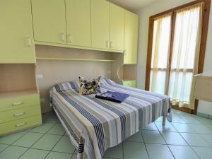 ein Schlafzimmer mit einem Bett mit einer gestreiften Decke in der Unterkunft Apartment Solmare-38 by Interhome in Rosapineta