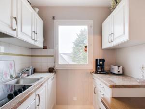 una cocina con armarios blancos y una ventana en Apartment Le Hoche by Interhome, en Dinard