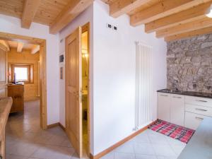 a kitchen with white cabinets and a stone wall at Apartment Albergo Diffuso - Cjasa Ustin-4 by Interhome in Barcis +26 photos