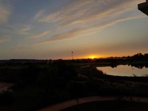 a sunset over a river with the sun in the distance at FamilyConfort Saidia in Saïdia