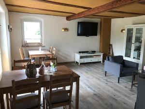 a living room with a table and a tv at Pension Schneidenbach in Reichenbach im Vogtland