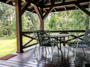 une table et des chaises sur une terrasse en bois dans l'établissement Holiday Home Zatylówka by Interhome, à Zatyle