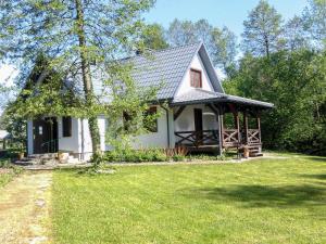 a small white house with a grass yard at Holiday Home Zatylówka by Interhome in Zatyle