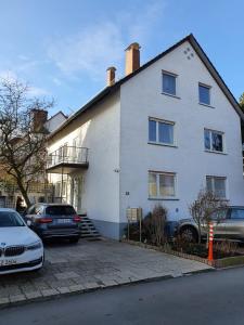 a white house with cars parked in front of it at Luxus Ferienwohnung in Pfungstadt