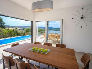 Un comedor con una mesa y un gran ventanal. en Holiday Home Jakša by Interhome, en Nečujam