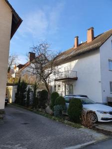 un coche aparcado frente a una casa blanca en Luxus Ferienwohnung, en Pfungstadt