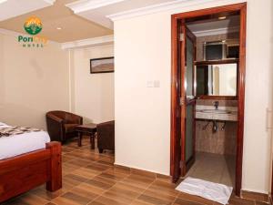 um quarto com uma cama e uma cozinha com um lavatório em Pori City Hotel em Nairobi