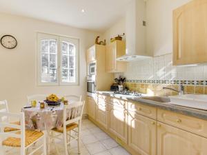 uma cozinha com um lavatório e uma mesa com cadeiras em Holiday Home Le Petit Biyou by Interhome em Dinard