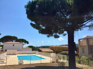 une villa avec une piscine et un arbre dans l'établissement Apartment Le Mas d'Esquières-7 by Interhome, aux Issambres
