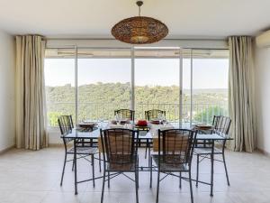 a dining room with a table and chairs and a large window at Holiday Home Nicoleine by Interhome in Cagnes-sur-Mer