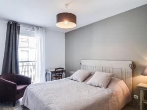 um quarto com uma cama, uma cadeira e uma janela em Apartment Confidence 2 by Interhome em Dinard