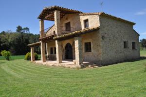 an old stone house on a grass field at Mas Saris in Peratallada