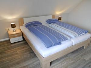 ein großes Bett mit blauen Laken und Kissen darauf in der Unterkunft Apartment Alina by Interhome in Marienhafe