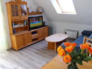 a living room with a couch and a table with orange roses at Apartment Gollwitzer Park - Insel Poel-4 by Interhome in Gollwitz