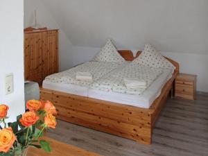 a bedroom with a wooden bed with flowers in a vase at Apartment Gollwitzer Park - Insel Poel-4 by Interhome in Gollwitz
