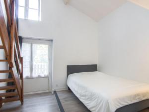 ein kleines Schlafzimmer mit einem Bett und einer Treppe in der Unterkunft Apartment Le Petit Robinson-8 by Interhome in La Richardais