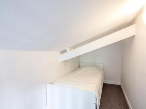 ein kleines Zimmer mit einem Bett in der Ecke eines Zimmers in der Unterkunft Apartment Le Petit Robinson-8 by Interhome in La Richardais