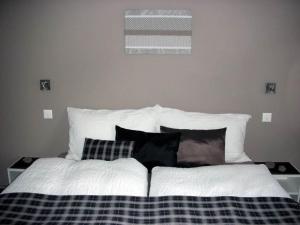 a bed with black and white sheets and pillows at Apartment Bergfreude Kuonen by Interhome in Saas-Grund