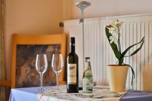 Una botella de vino y dos copas en una mesa en Gasthof Bader, en Deutsch Goritz