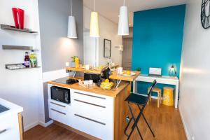 une cuisine avec un comptoir en bois et un mur bleu dans l'établissement KASA AMAZUR - Centre ville & Cosy, à Saint-Étienne