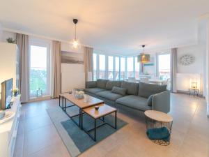 a living room with a couch and a table at Apartment Pura vida with balcony by Interhome in Bredene