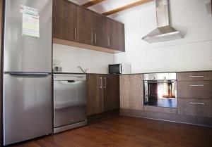 a kitchen with stainless steel appliances and wooden cabinets at Casa La Lourdes in Ainet de Besan
