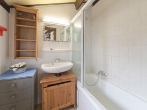 デ・ハーンにあるHoliday Home Polderhuis nr-142 by Interhomeの洗面台、シャワー、浴槽を備えたバスルーム