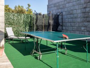 a ping pong table and a chair on a patio at Holiday Home Ivana by Interhome in Selca