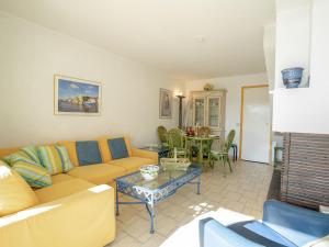 a living room with a couch and a table at Holiday Home Hélios by Interhome in Le Grau-du-Roi +16 photos