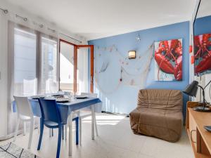 een eetkamer met blauwe muren en een blauwe tafel en stoelen bij Studio Le Mercure by Interhome in Le Grau-du-Roi