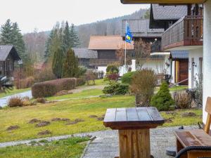 a wooden bench in a yard with a house at Apartment Am Hohen Bogen-24 by Interhome in Arrach