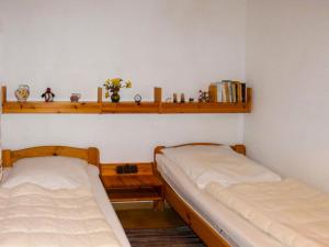 two beds in a room with wooden shelves at Apartment Am Hohen Bogen-24 by Interhome in Arrach