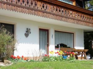 ein Haus mit einer Bank und Blumen im Hof in der Unterkunft Apartment Am Hohen Bogen-25 by Interhome in Arrach