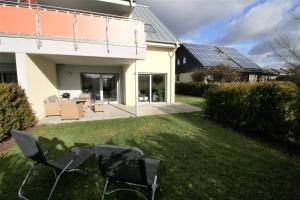 um grupo de cadeiras no pátio de uma casa com painéis solares em Loreley Hills Residence em Sankt Goarshausen