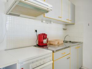 une cuisine avec un appareil rouge sur le comptoir dans l'établissement Apartment Les Floralies II-11 by Interhome, au Grau-du-Roi