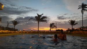 un grupo de personas en una piscina al atardecer en Calypso Sunset, en Iranawila